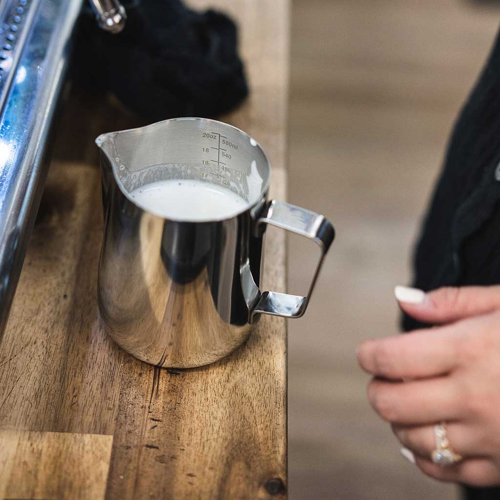 Barista Basics milk pitcher in a latte-art workflow illustrating free-pour milk control