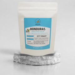 Honduras APROCOMSA coffee pouch displayed on a stone pedestal