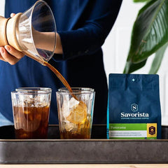 Pouring iced coffee beside a Panorama half-caff bag