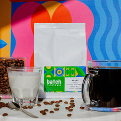 Batch Coffee Brazil Oberon bag beside coffee beans, a drinking glass and a mug of coffee