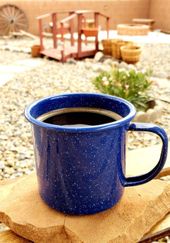 Blue enamel mug of black coffee on a wooden surface — Al Gusto Cowboy Blend Medium-Dark Coffee