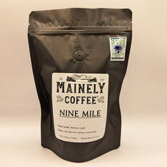Single black Mainely Nine Mile pouch on a warm neutral surface