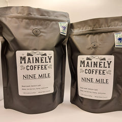 Two differently sized black Nine Mile coffee bags standing together