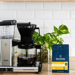Yesso espresso decaf bag beside a filter coffee brewer