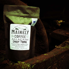 Allagash Ghost Trains coffee bag resting in a rusted machine cavity