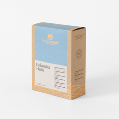 Angled front view of Pink Elephant Colombia Huila packaging with a light blue panel