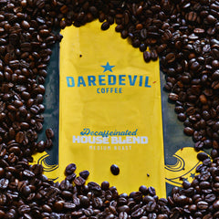 Decaf House Blend bag displayed in roasted coffee beans