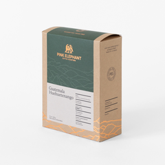 Angled front view of Pink Elephant Guatemala Huehuetenango packaging with a forest green panel