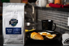 Bespoke ground bag beside a croissant and black mug on a kitchen counter