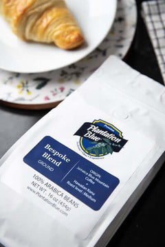 Ground Bespoke coffee pouch near a croissant plate in an overhead breakfast view