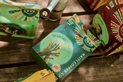 Overhead angled view of the Tèt āndi Laye package among colorful coffee bags