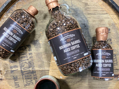 Three barrel-aged coffee bottle sizes arranged on a wooden surface — Hemisphere Bourbon Barrel-Aged Coffee, 5.5 oz Bottle