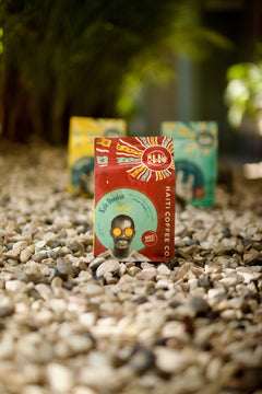 Red Kafe Dondon bag with its portrait and circular seal facing the camera outdoors