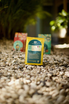 Back information panel of the yellow Sanctuary bag on gravel