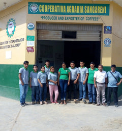 Group standing outside the Cooperativa Agraria Sangareni building