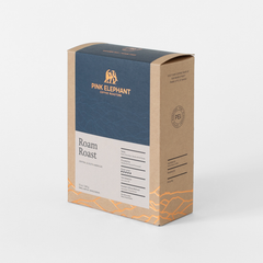 Angled front view of Pink Elephant Roam Roast packaging with a navy panel