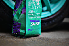 Rear and side of SLUSH coffee bag next to a car
