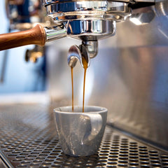 Espresso flowing from a portafilter into a cup — PT’s Southpaw Light-Medium Espresso Coffee Blend