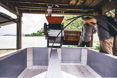 Olympia Decaf Asterisk Colombian Sugarcane Coffee — coffee-processing equipment beside a tiled tank