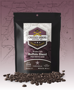 Crossed Sabers Buffalo Blend Medium Roast Coffee bag with scattered beans against a purple map backdrop