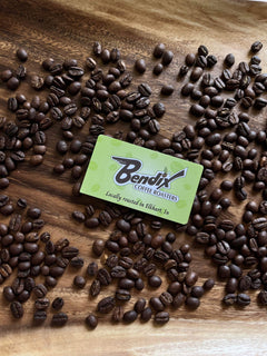 Bendix business card surrounded by roasted coffee beans on wood — Bendix Colombian EA Decaf Coffee gallery
