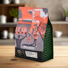 Matchday bag standing on a light wooden table — Kickoff Matchday Peru Light Roast Coffee, 12 oz