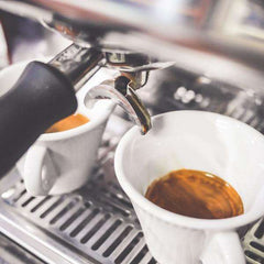 Passport Milano Caramel and Vanilla Espresso Coffee — espresso flowing into white cups beneath a machine group