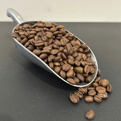 Scoop of roasted coffee beans on the Pilot Blend page