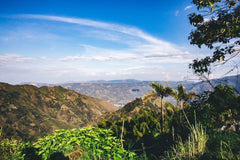 Olympia San Sebastián Reserva Colombian Coffee — wide mountain-valley view with cultivated hillsides
