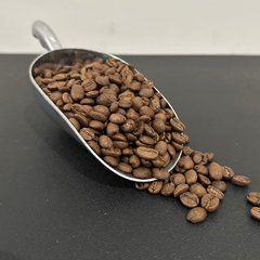 Scoop of roasted coffee beans beside Wake Turbulence product photos