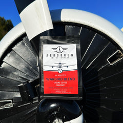 Warbird coffee bag in front of an aircraft engine
