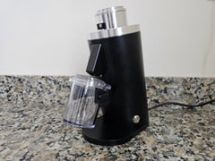 Black Turin DF54 grinder with dosing cup on a kitchen counter