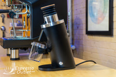 Black Turin DF54 grinder beside an espresso machine