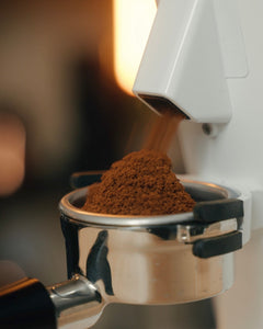 White DF64 Gen 2.7 grinding coffee directly into a portafilter